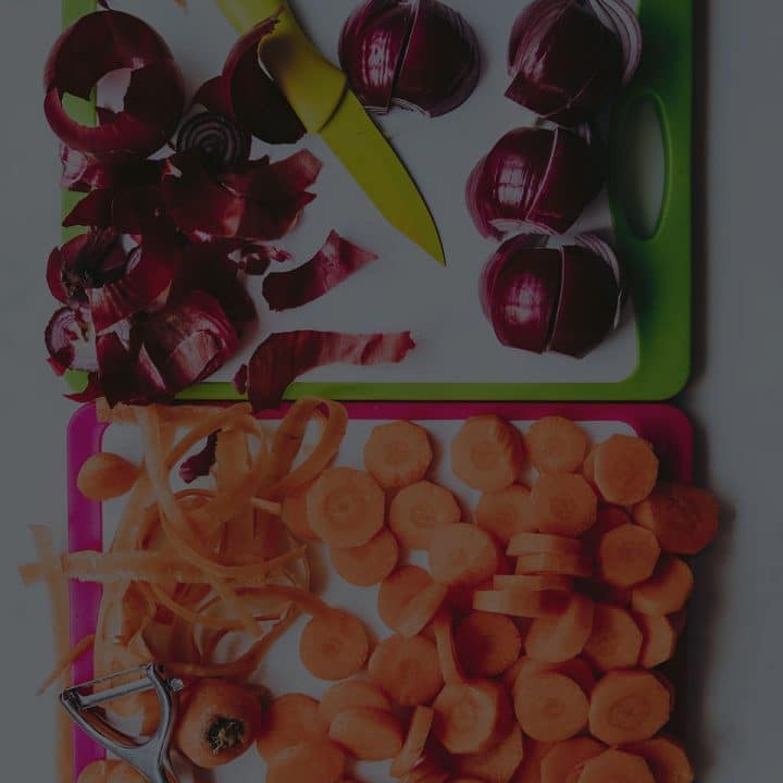 Black overlay on two cutting boards with knives, carrots, and onions.