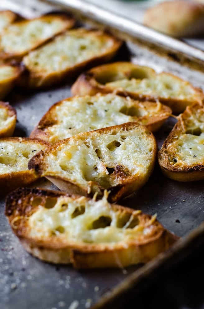 Pieces of homemade garlic toast on a baking sheet