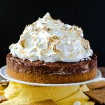 A s'mores pie piled very high with toasted marshmallow fluff.
