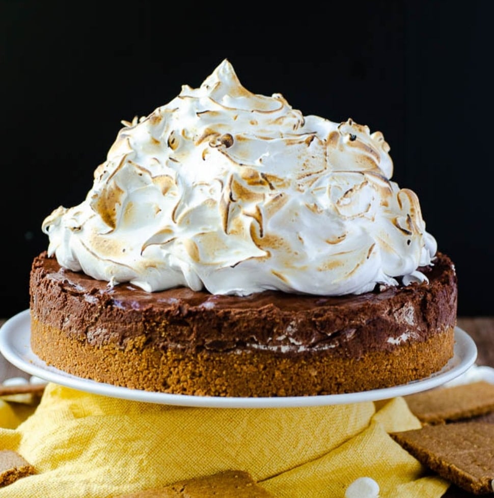 A s'mores pie piled very high with toasted marshmallow fluff.