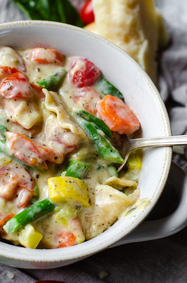 spoon inside a white bowl of one pot lasagna soup