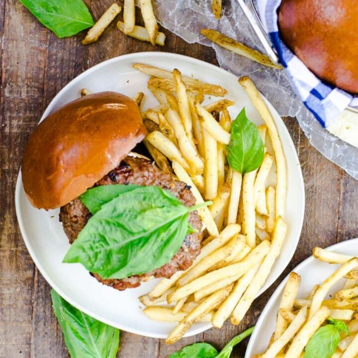A plate filled with a side of fries and a burger topped with lettuce