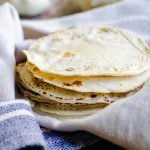 A stack of homemade tortillas in a kitchen towel