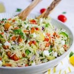 Bowl of pasta salad with wooden serving spoons
