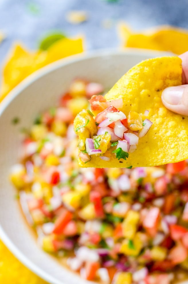 Closeup of pineapple salsa on a tortilla chip