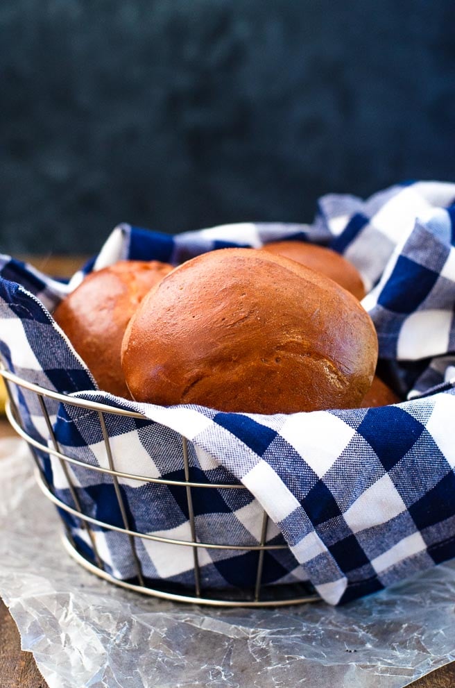 basket of buns wrapped in a blue gingham kitchen towel