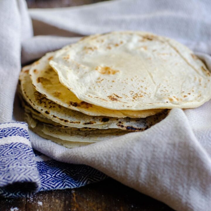 A hand towel topped with freshly made tortillas