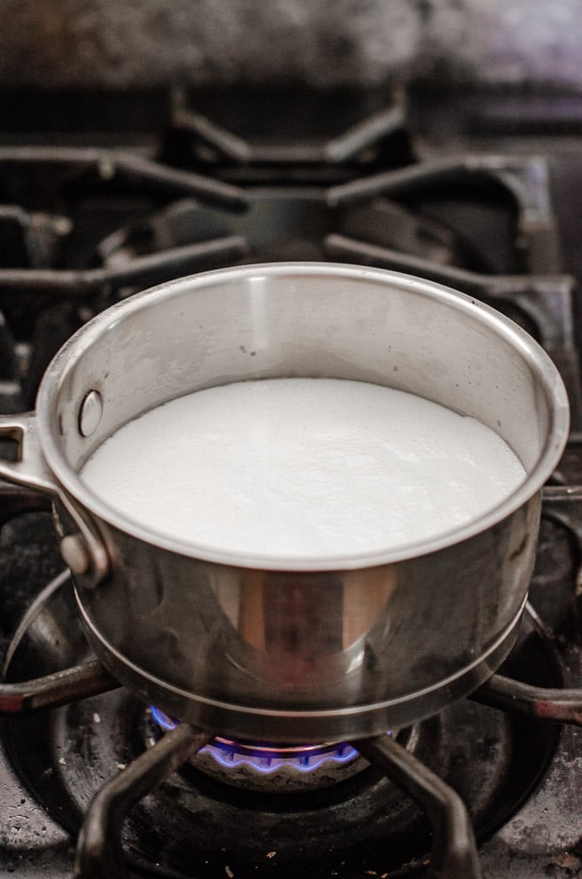 a pot of milk on a gas burner