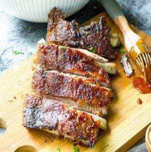 Cut oven baked baby back ribs on a cutting board