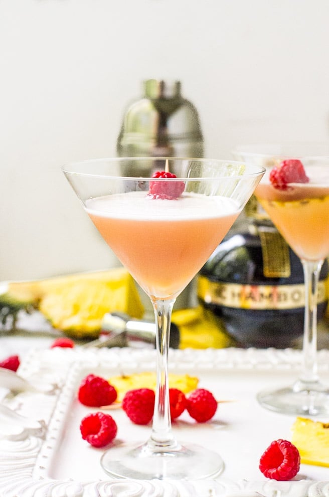 Two glasses of french martinis surrounded by fruit.