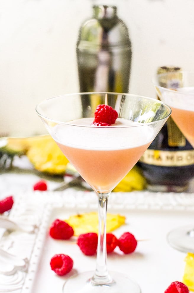 A garnished french martini recipe on a white tray.