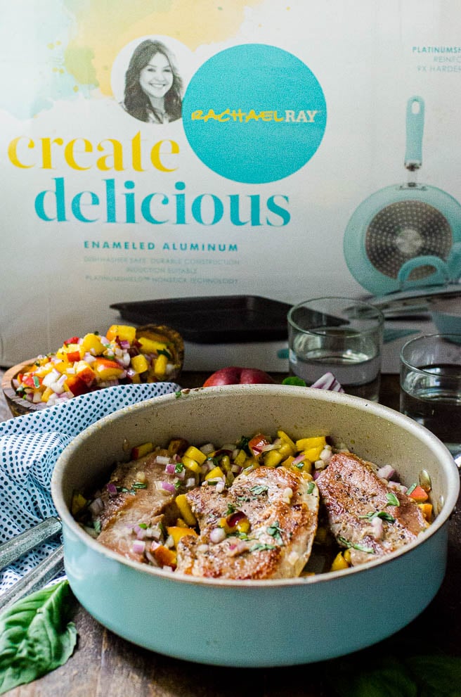 a blue Rachel Ray skillet in front of the watercolor Create Delicious cookware box.