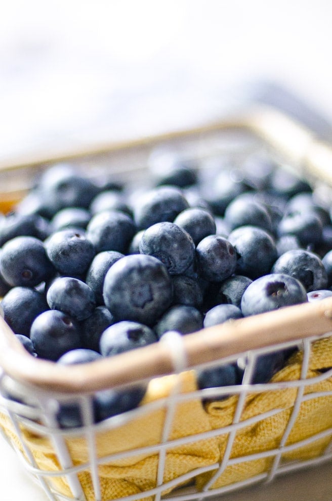 Close up of fresh blueberries in a small basket.