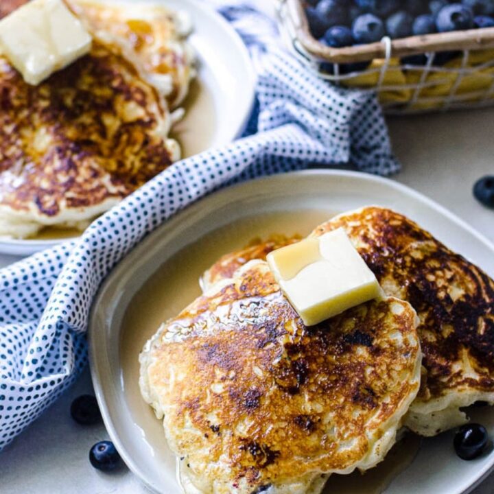 A plate with slices of pancakes topped with syrup and butter