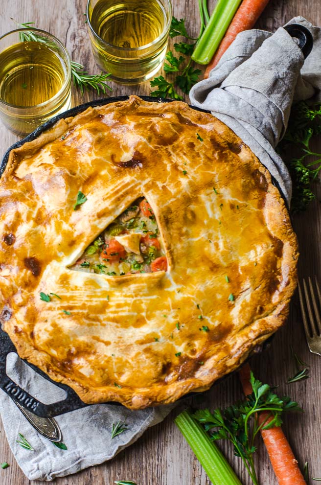 A napkin wrapped around the hot handle of a skill turkey pot pie.