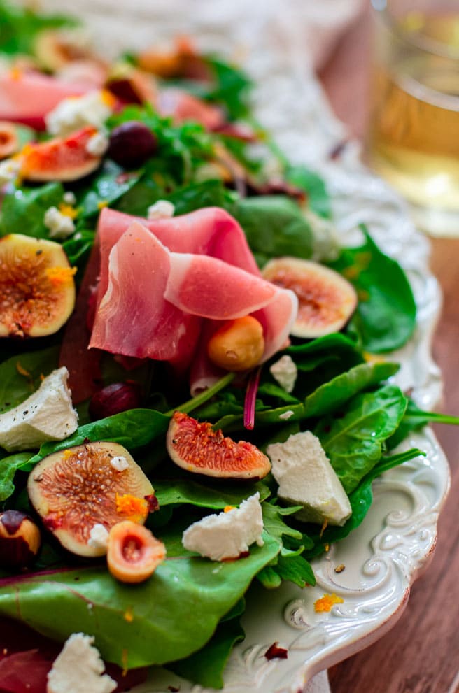 close up of prosciutto and black figs on a salad.