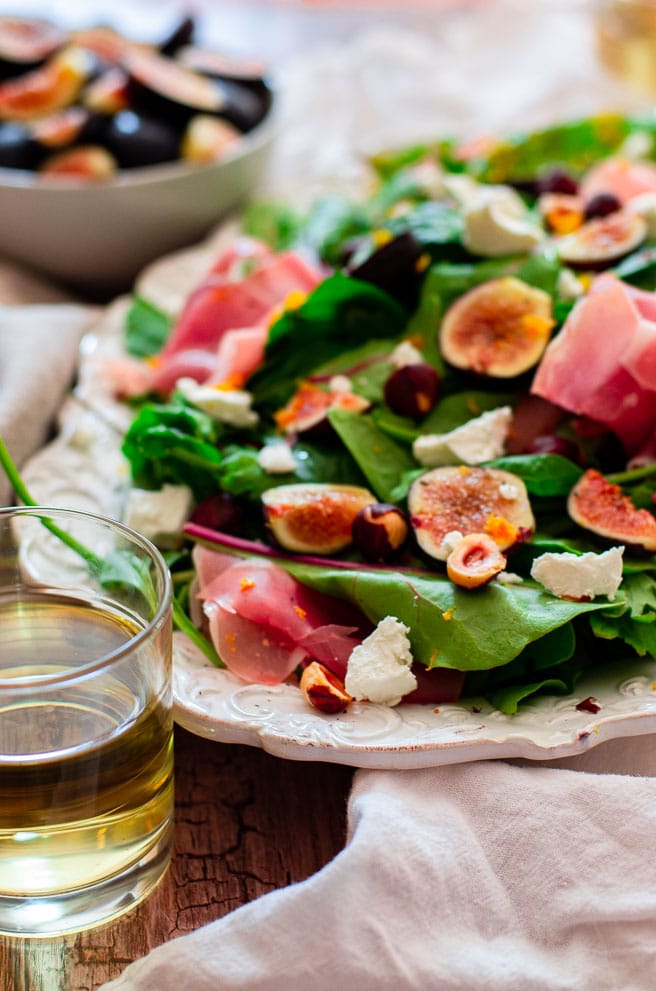 Things to serve with fig salad around a platter of salad. Includes white wine, additional figs, crusty bread, etc...