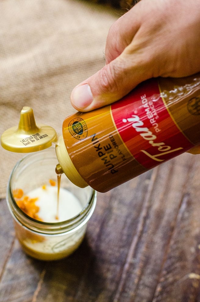 Torani pumpkin pie syrup being poured into a container to make cold foam.