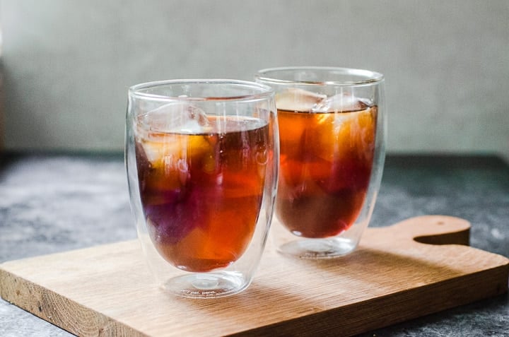 Two cups of cold brew coffee on a wooden board.