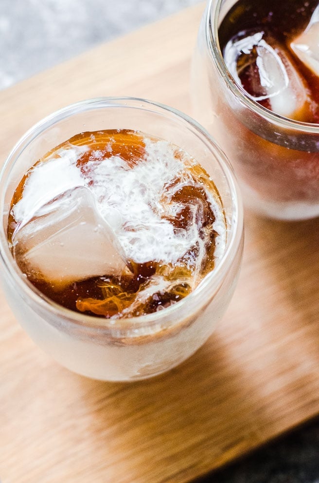 Overhead view of cream next to ice cubes in a cup.