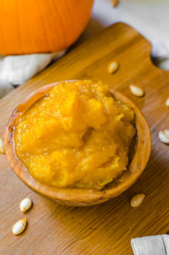 a wooden bowl filled with homemade pumpkin puree.