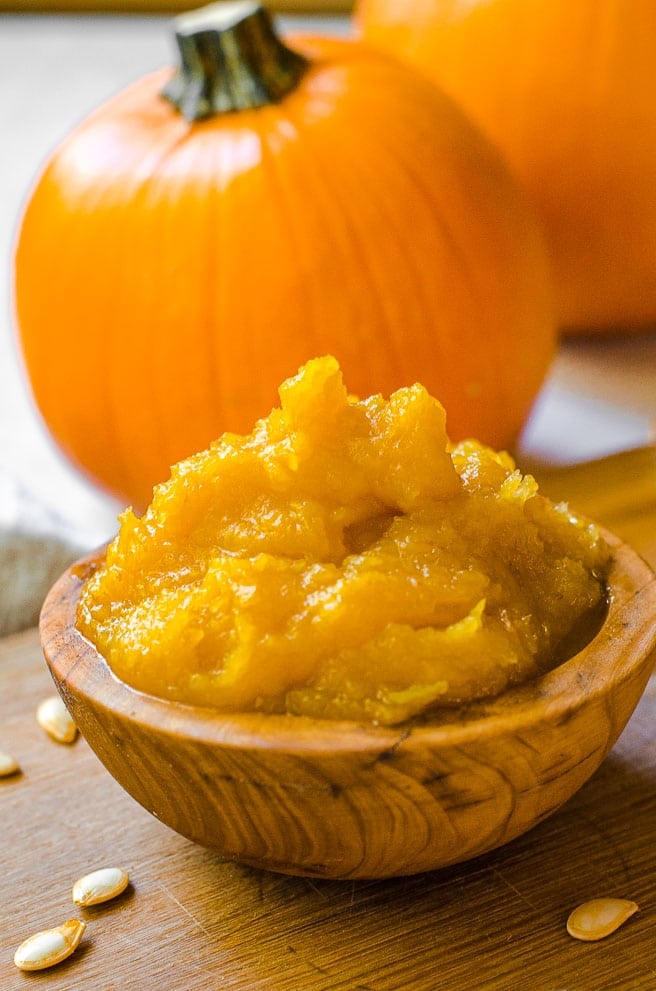 Close up of a wooden bowl filled with homemade pumpkin puree.