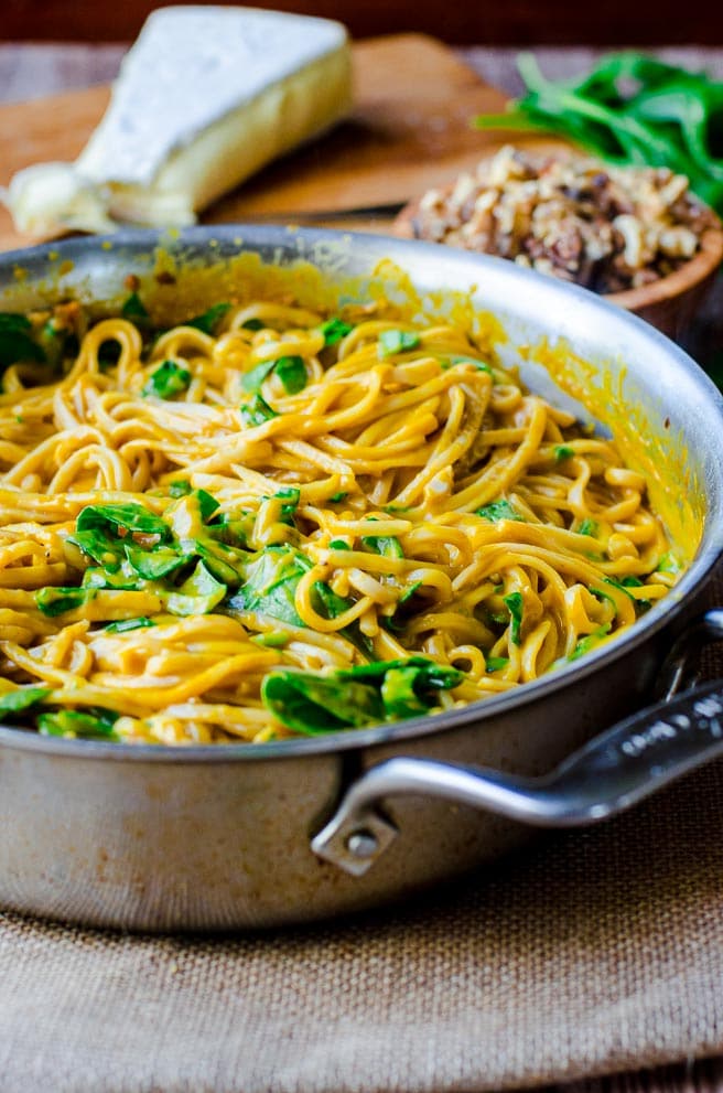 A stainless steel pot filled with pasta and spinach.