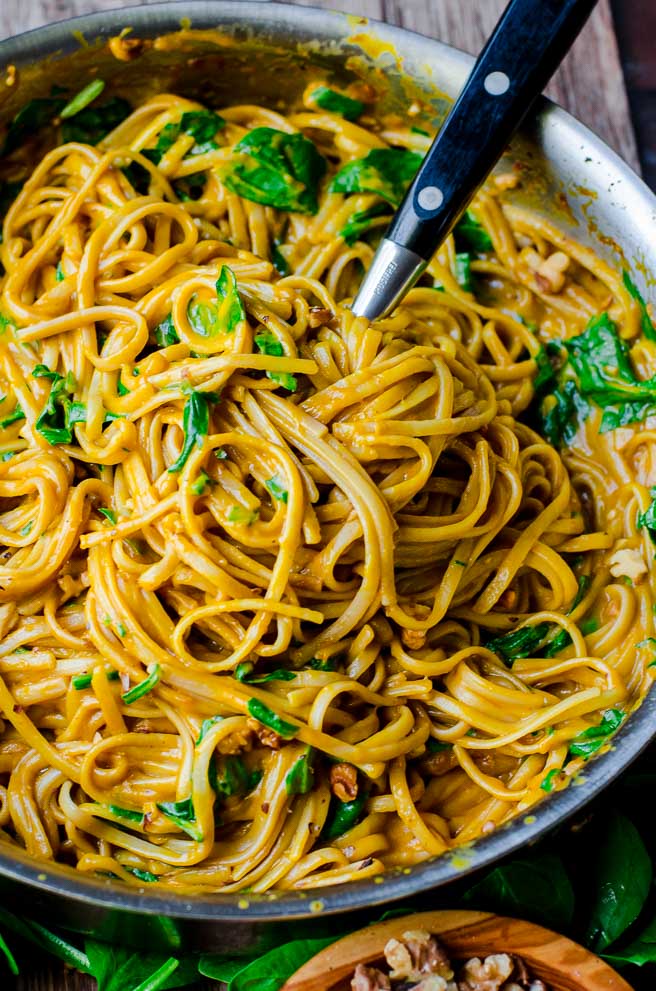 Overhead view of pasta spoon tossing the pumpkin pasta in the pot.