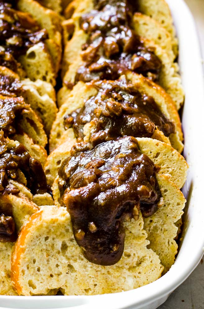 Close up of pecan praline brown sugar topping oozing over the top of bread slices.