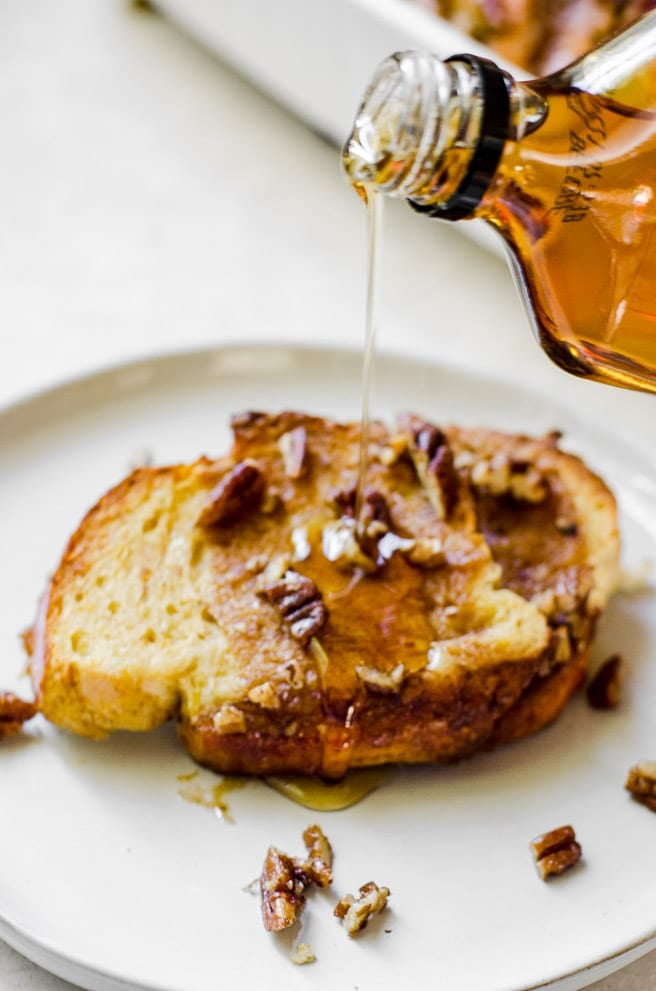 Syrup being poured out of a bottle and onto french toast.