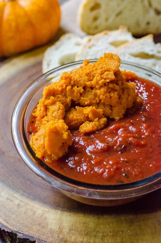 A bowl filled with pumpkin puree and fire roasted tomatoes for this shakshuka recipe. 