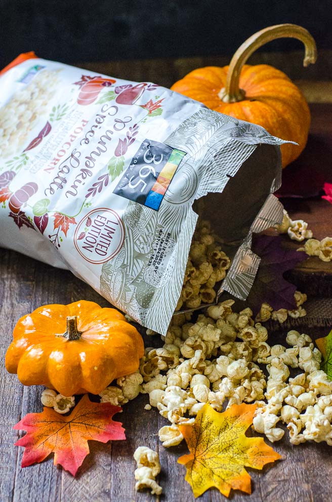 A bag of fall flavor pumpkin spice latte popcorn pouring out the popped kernels.