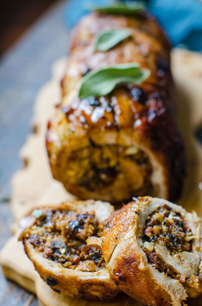 Close up of a slice of tender stuffed pork tenderloin with prune stuffing spilling out.