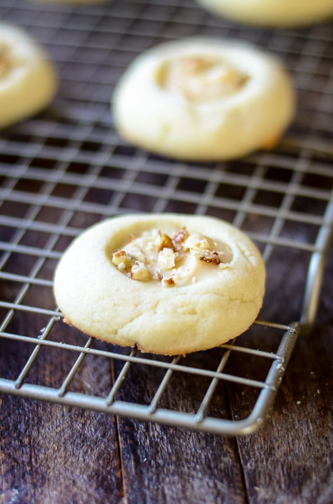 Pecans on brown butter iced thumbprint cookies.