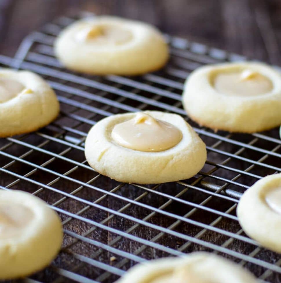A cooling rack of brown butter iced thumbprint cookies.