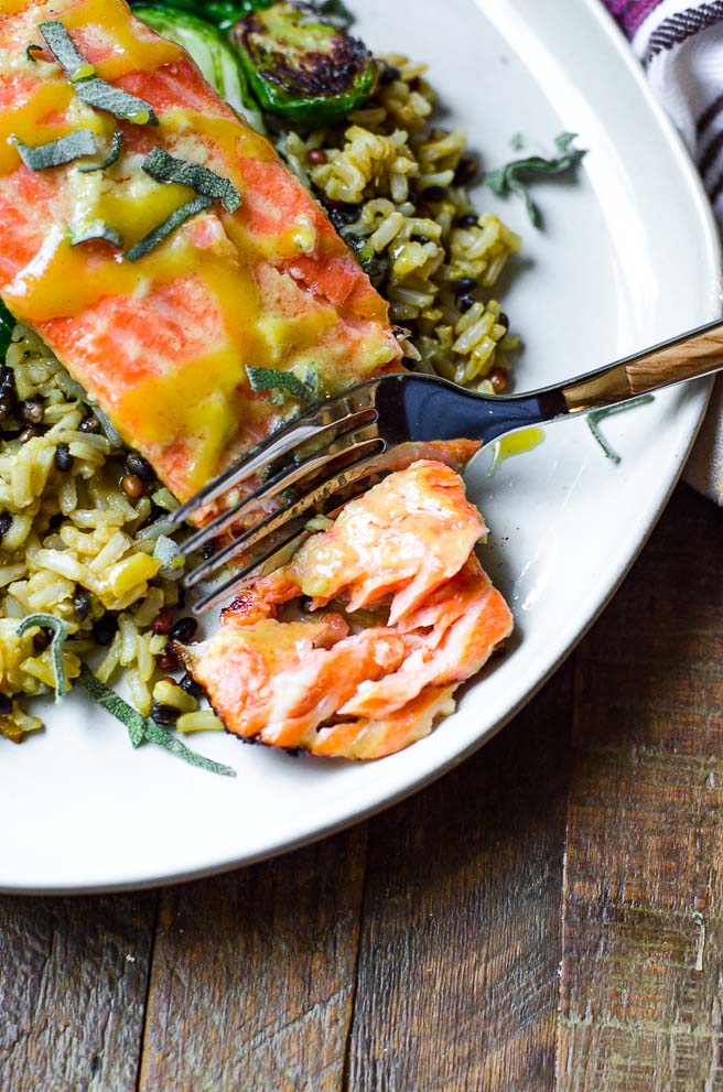 Overhead view of a fork cutting into a salmon fillet.