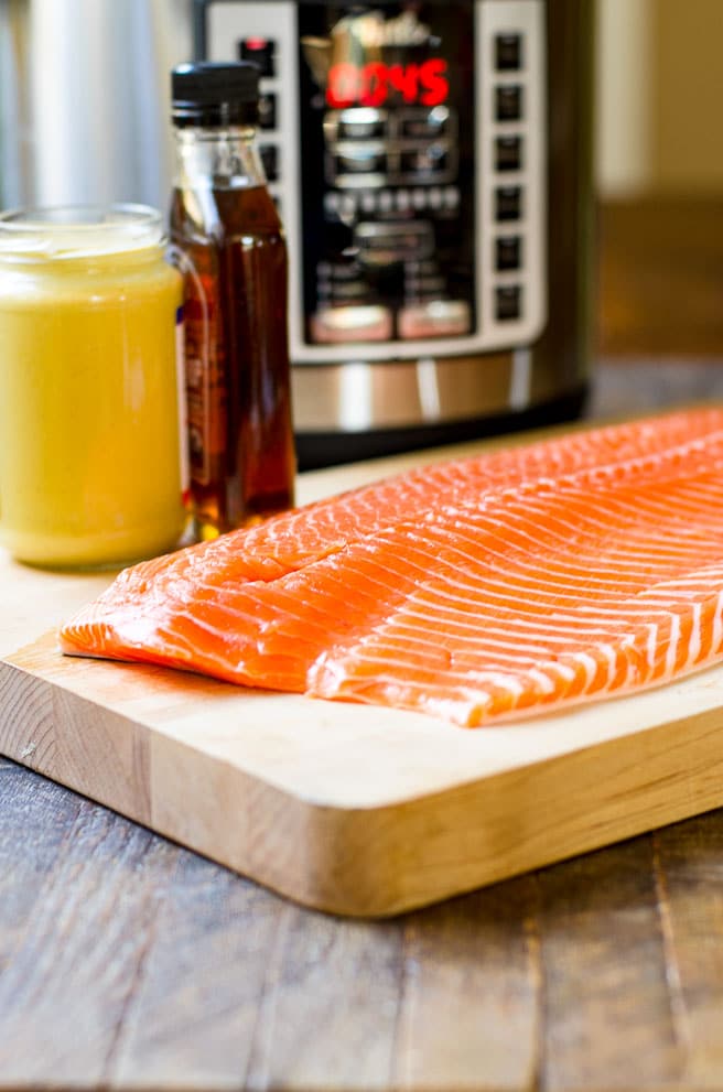 A whole salmon fillet on a cutting board.