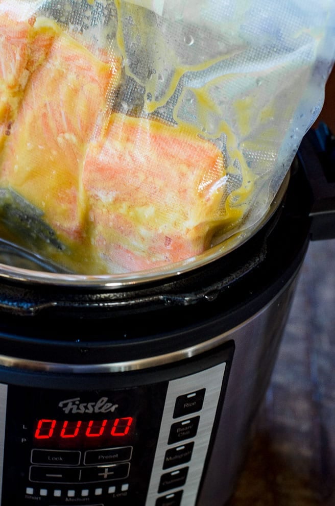 A vacuum sealed bag of salmon being removed from a sous vide.