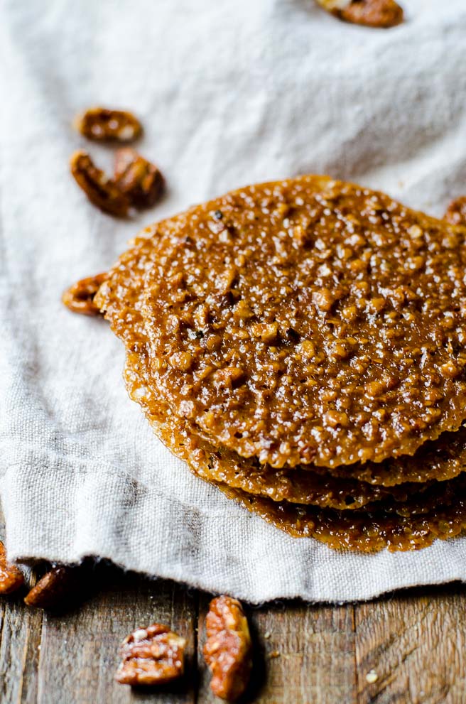 A small stack of pecan lace cookies showing the texture and size of the added pecans.