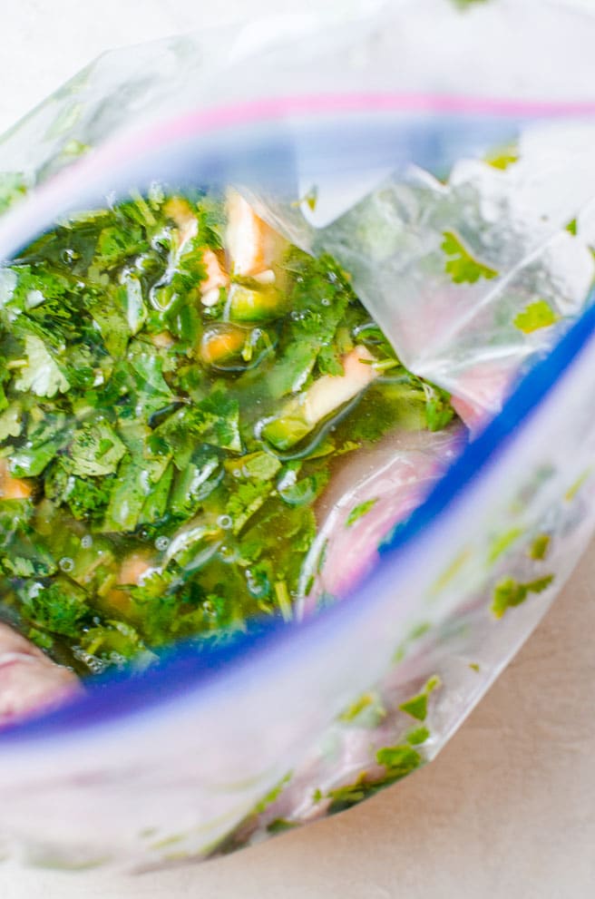 Overhead view into a bag marinating flank steak for carne asada.