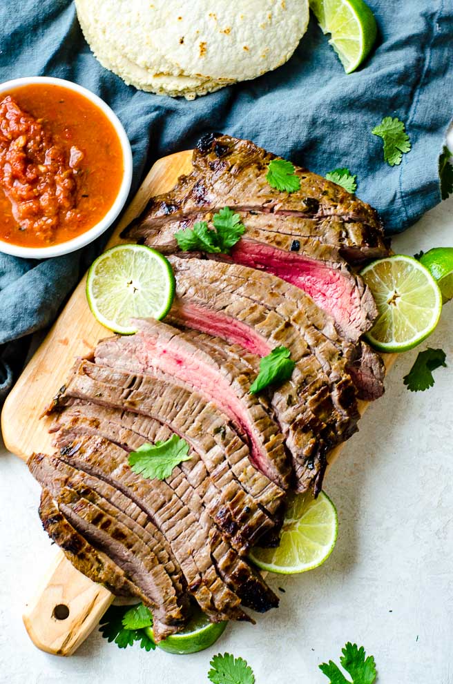 Overhead view of carne asada meat on a cutting board.