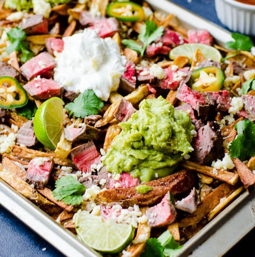 Perfect for game day, these crispy french fries are topped with melted cheese, sour cream, guacamole, and smoky carne asada meat.