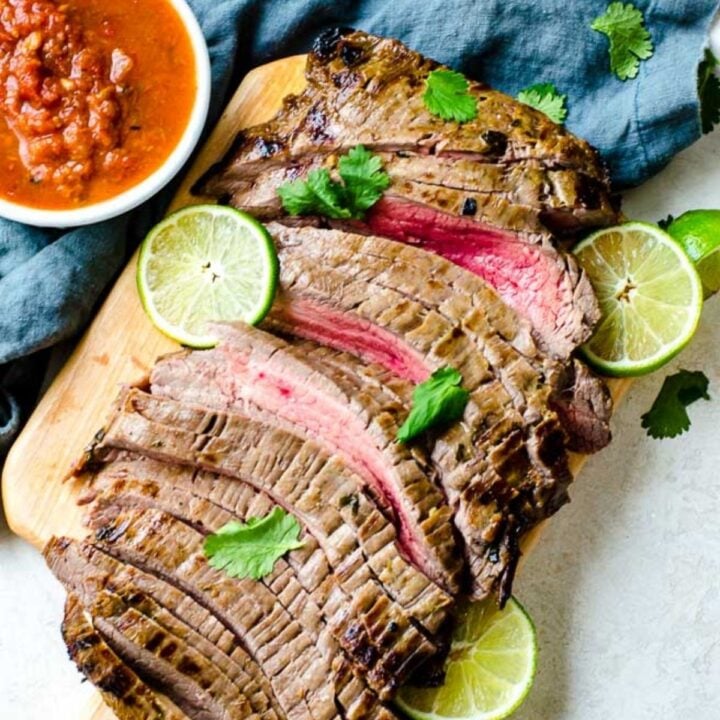 A cutting board holding a whole carne asada meat
