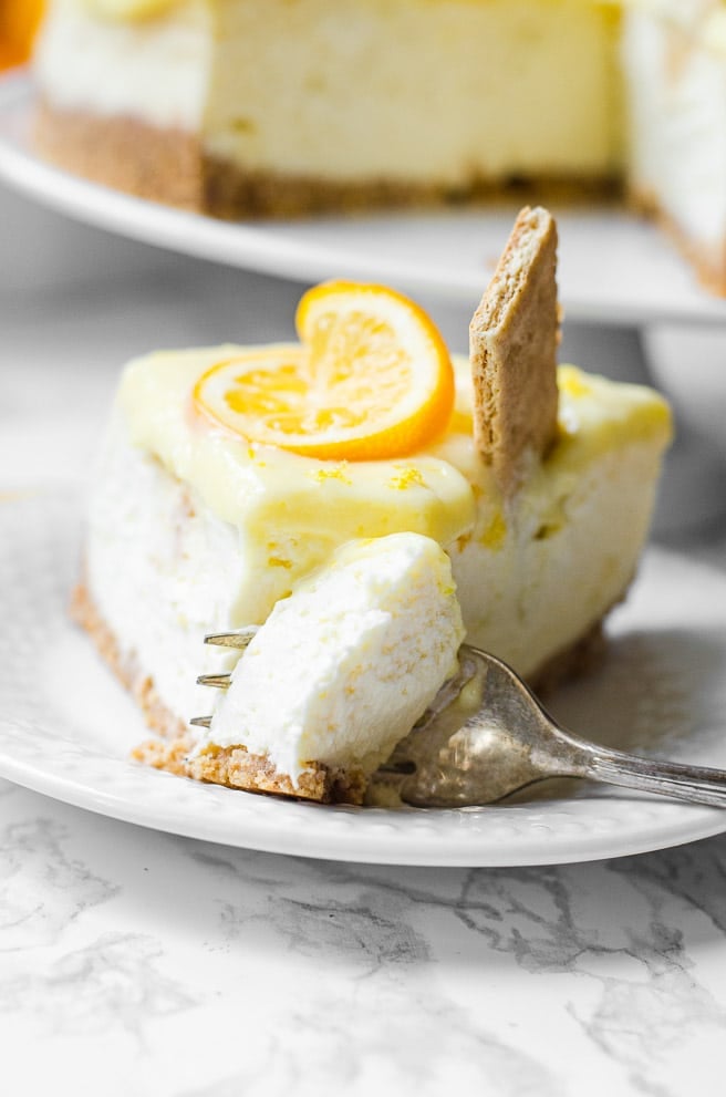 A fork taking a bit out of a slice of cheesecake.