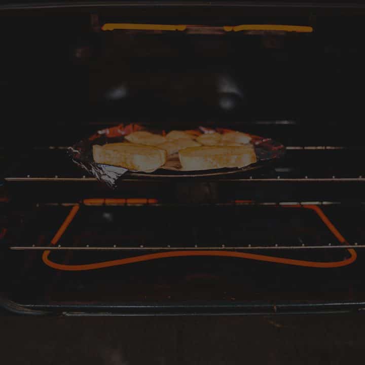 Black overlay on a pan of bread toasting under a broiler.