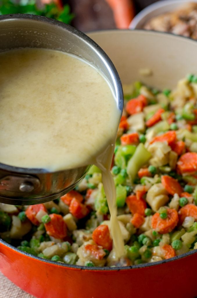 Scalded liquid in a pot being poured into vegetables.