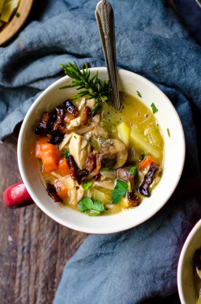 Overhead view into a bowl of leftover turkey vegetable soup.