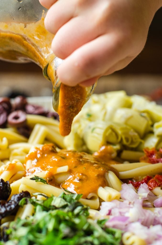 Vinaigrette being poured onto the pasta.