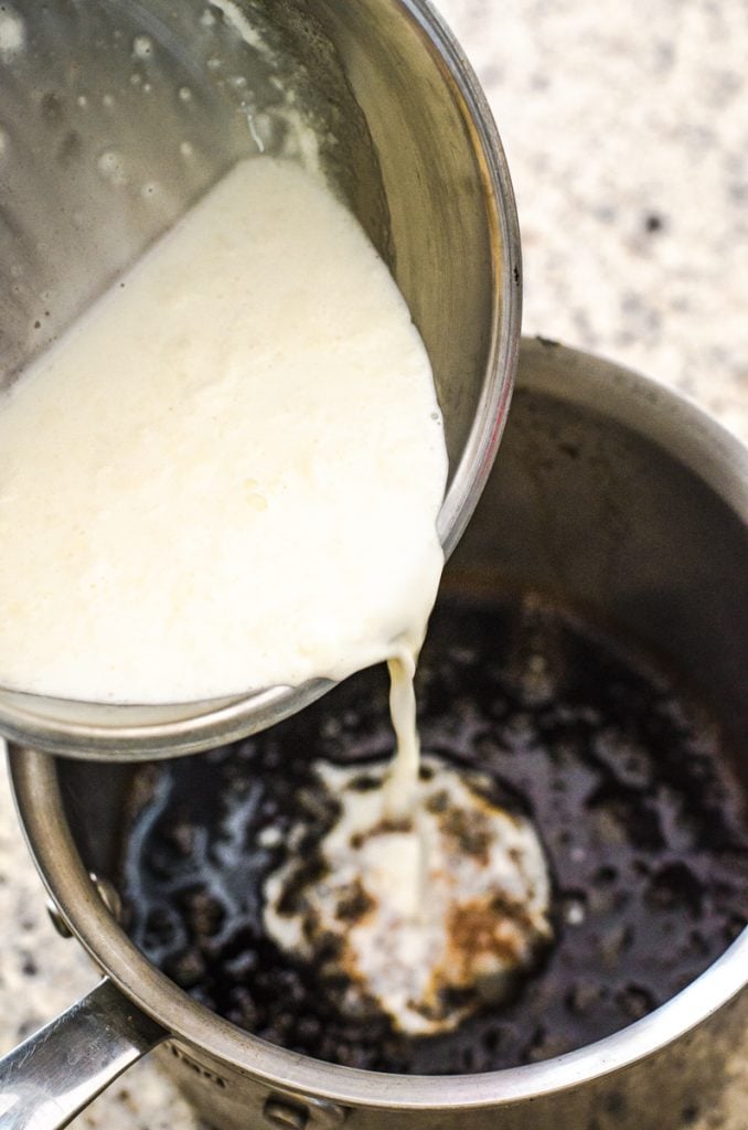 A pot pouring scalded milk into caramel sauce.