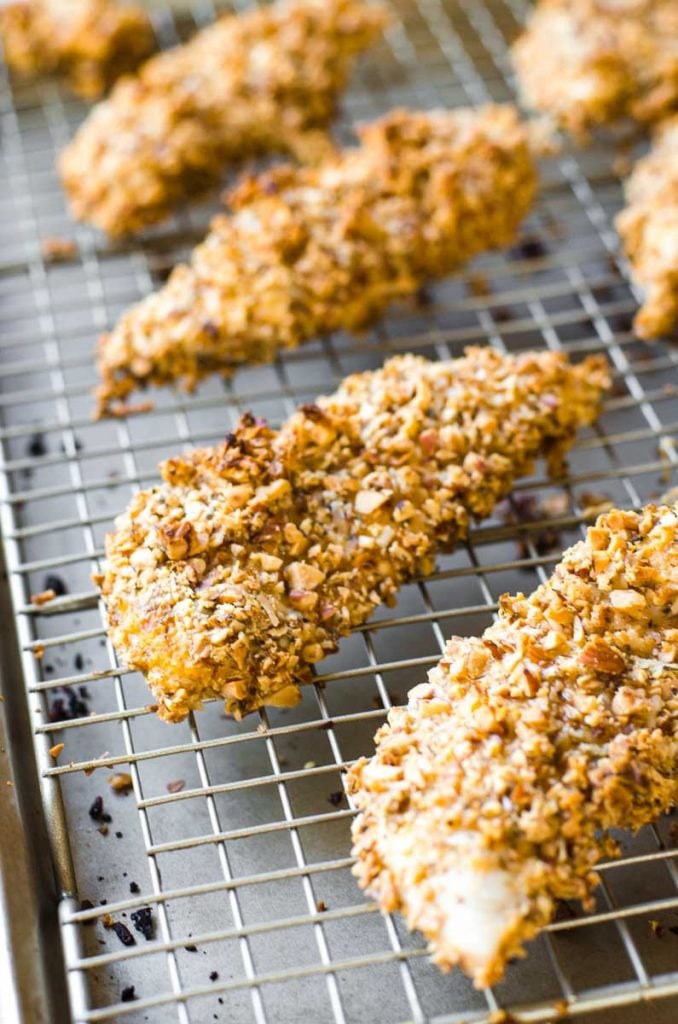 Almond crusted chicken tenders on a baking rack.